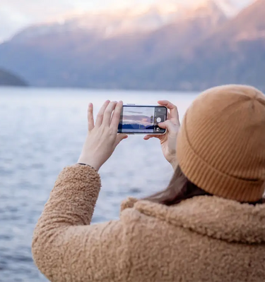 Kvinna fotograferar havet med mobil