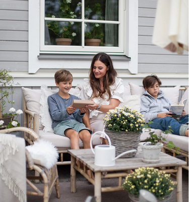 Mamma ger Refurbly-mobil till sitt glada barn på altanen ute