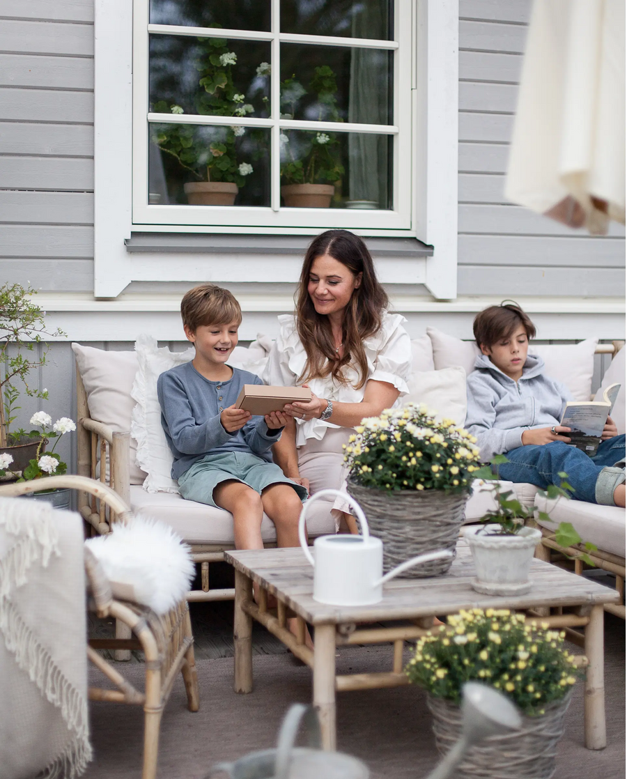 Mamma ger Refurbly-mobil till sitt glada barn på altanen ute