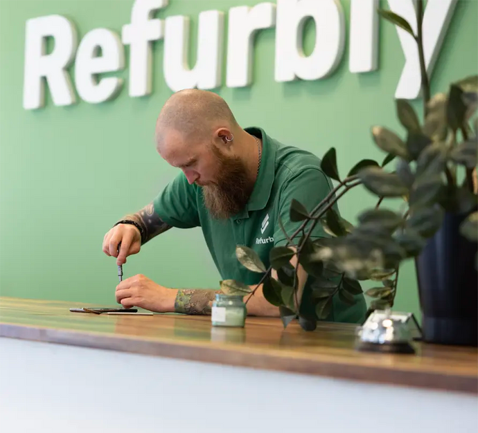 Mobilreparatör genomför reparation på mobil i butik